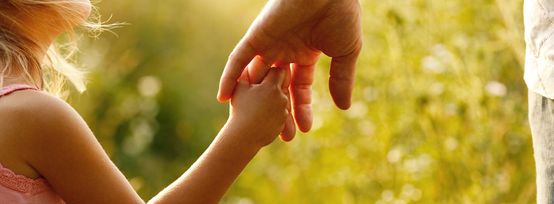 Little girl holding her father's hand